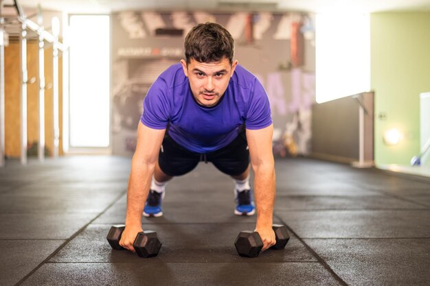 ジムの腕立て伏せで運動する男