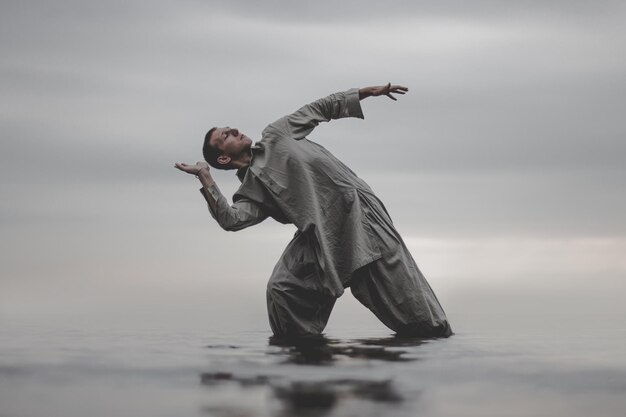 Photo man exercising in sea against sky