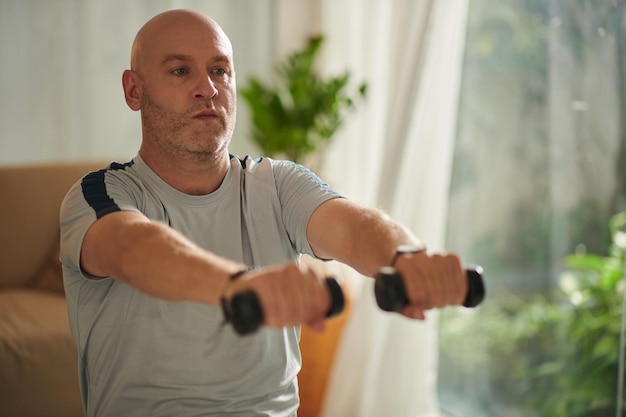 Uomo che si esercita con i dumbbells