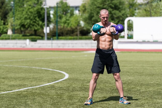 屋外でケトルベルで運動する男