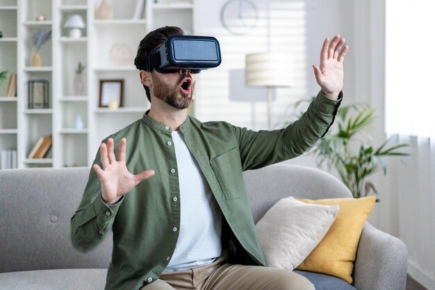 man experiencing virtual reality with vr headset at home expressing surprise in modern living room
