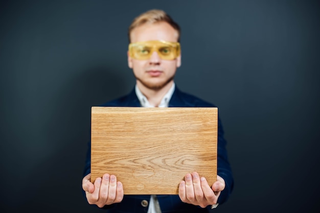 Man expert in woodworking holding a wooden building material
sample