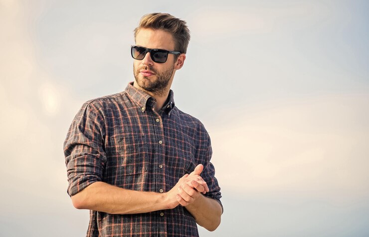 Photo man eyewear model outdoors blue sky background handsome guy wear sunglasses perfect vision eyes health fashionable sunglasses hipster man in trendy sunglasses ultraviolet protection concept