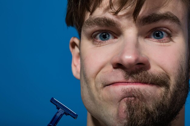 Man face half shaved and bearded with razor