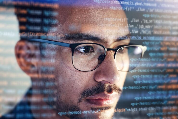 Photo man face and programming at night with overlay or dashboard of code malware or software at the office male person coder or programmer working late in development problem solving or algorithm