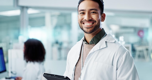 Man face and scientist with tablet in laboratory and online research of genetics specialist in healthcare Asian doctor portrait and happy at work in pharmaceutical career and working on innovation