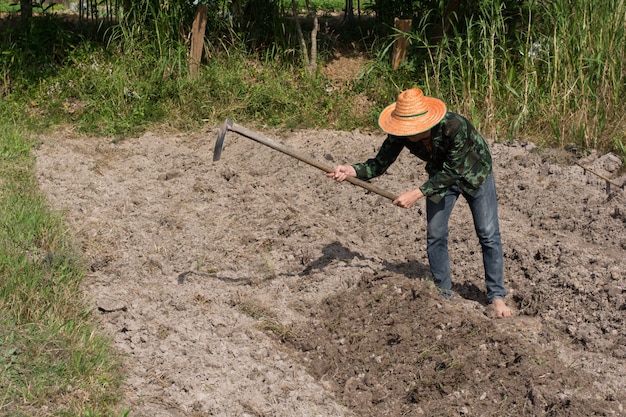 Photo man farmer holding spade at field in nakhon phanom,thailand