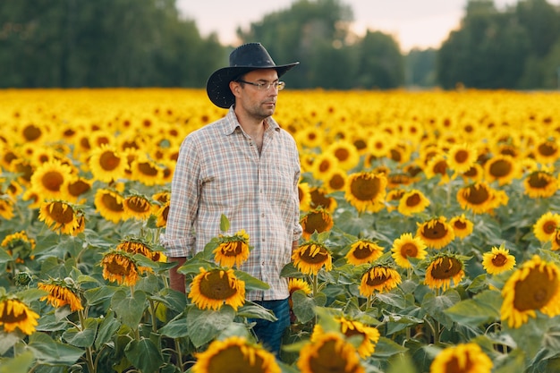 Man farmer standing in a sunflower field