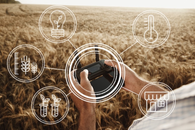 Foto agricoltore dell'uomo in piedi nel campo di grano e controllo delle tecnologie dei droni nel concetto di agricoltura