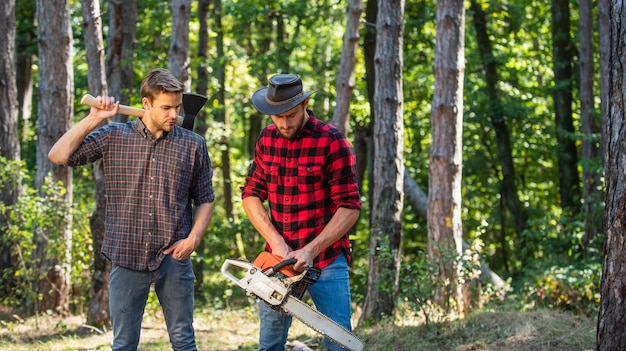 Man farmers relax in forest rangers use lumberjack equipment\
lumberjack with saw and ax harvest firewood hiking in deep wood\
forest care at vacation summer or spring activity this is the\
life