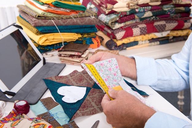 Man fashion designer measuring a piece of fabric