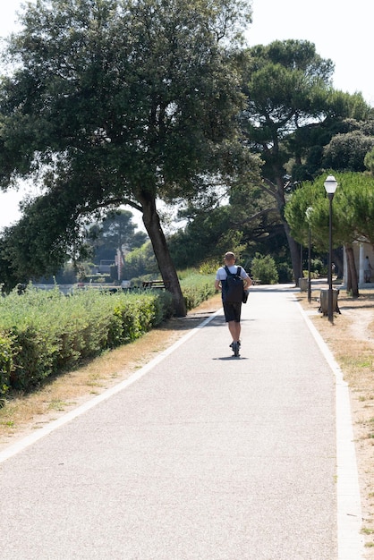 Man fast driving electric scooter in bike way pathway