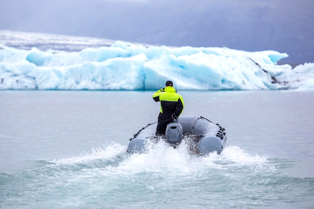 Человек на быстрой моторной лодке, плывущей по ледниковой лагуне в Исландии