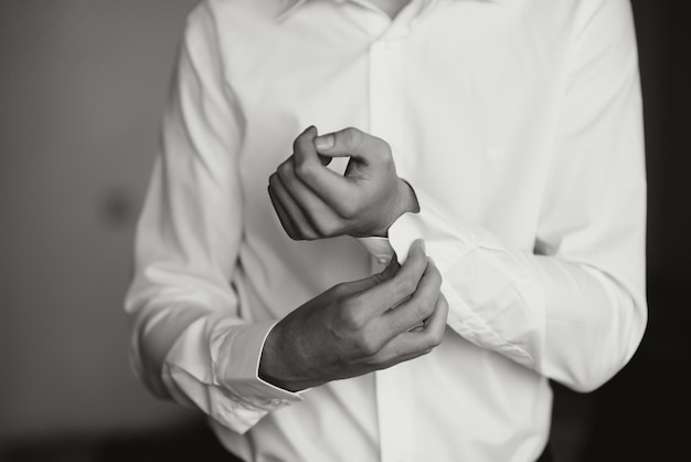 A man fastens buttons on his shirt.