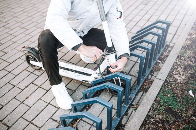 A man fastens an electric scooter on a lock theft of bicycle\
scooters