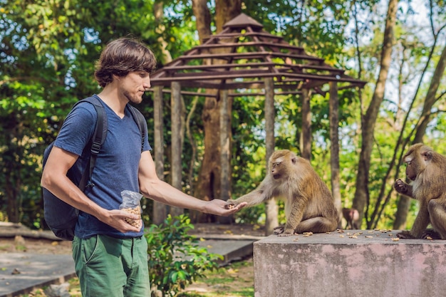 The man feeds the monkey whith nuts