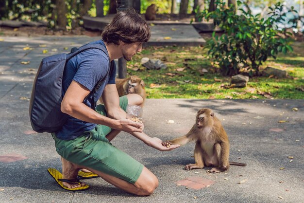 The man feeds the monkey whith nuts