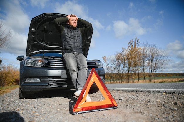 A man feel stress because his car is broken down