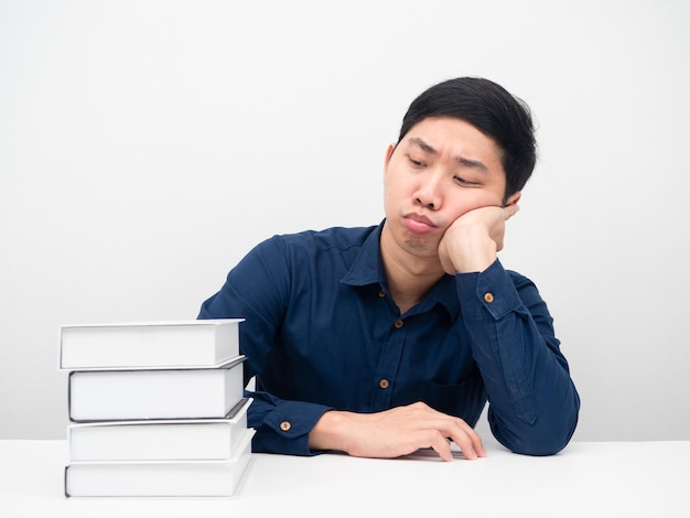 Man feeling bored looking at books on the table