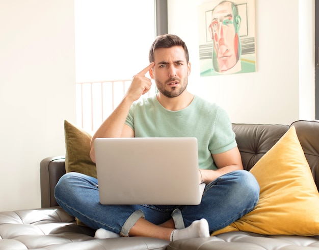 man feeling confused and puzzled, showing you are insane, crazy or out of your mind