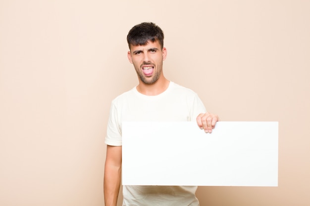 man feeling disgusted and irritated, sticking tongue out, disliking something nasty and yucky