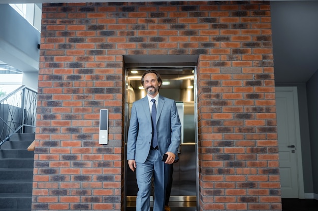 Man feeling motivated. Grey-haired businessman wearing suit and tie feeling motivated before meeting