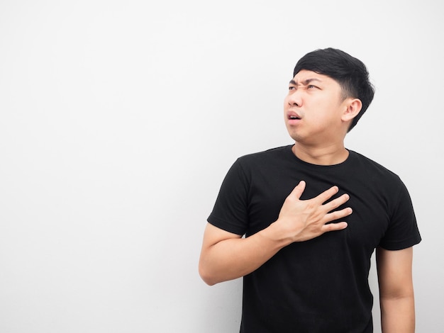 Man feeling pain his chest looking at copy space