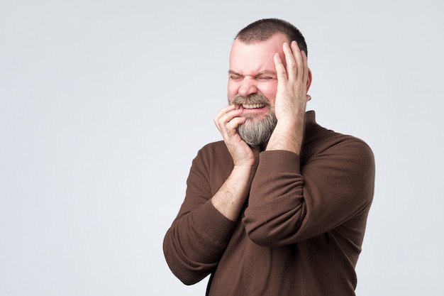 Man feeling pain suffering from bad toothache