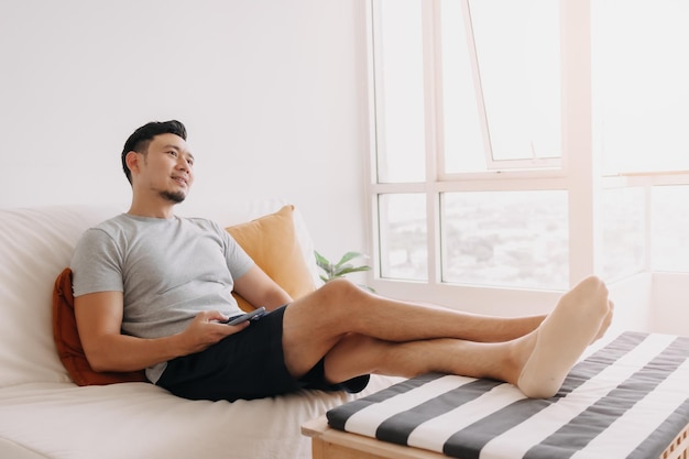 Man feels relax and relief with trading business on mobile in his home