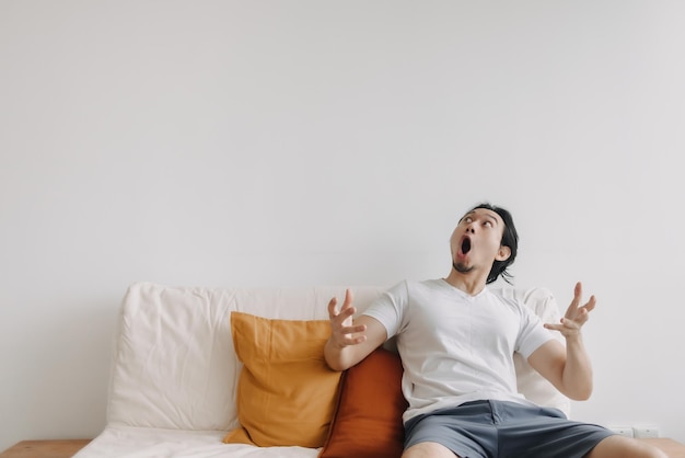Man feels surprised and shocked at empty copy space wall in living room