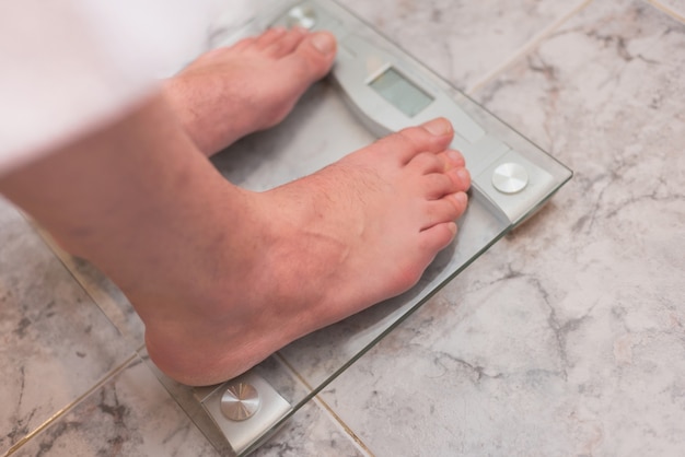 Man feet standing on weight scale