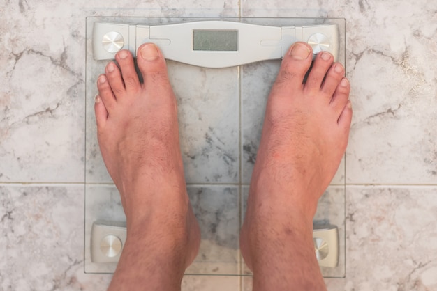 Man feet standing on weight scale