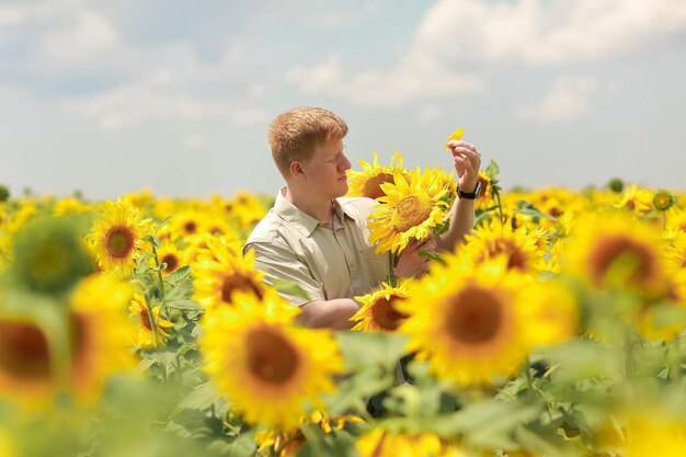 A man in a field of sunflowers looks at the camera