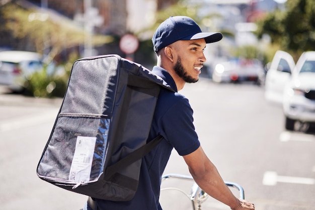 Man fiets en levering in de stad met zak van logistieke distributiedienst en fastfood bestel Koerier milieuvriendelijk vervoer of bezorger reizen op fiets met e-commerce product in de stedelijke straat