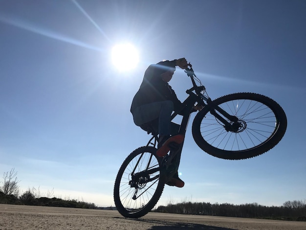 Foto man fietsen op het veld tijdens een zonnige dag