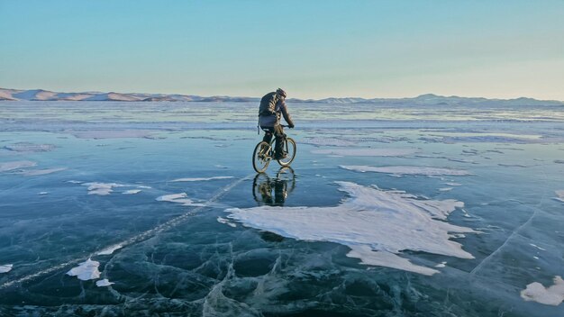 Man fietst op het ijs IJs van het bevroren Baikalmeer