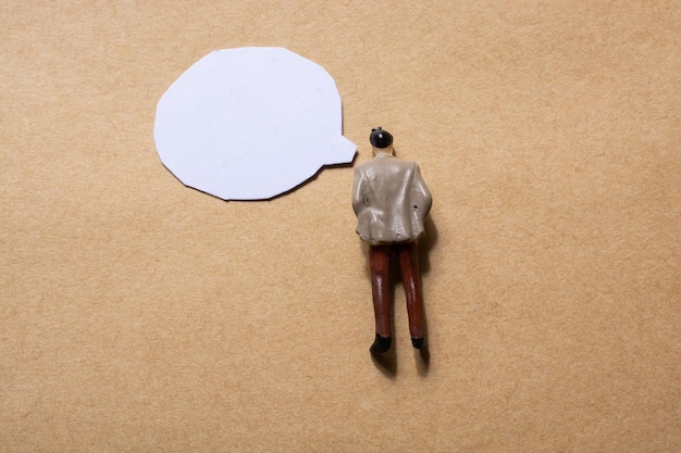 Man figurine and Mini speech bubbles cut out of paper in view