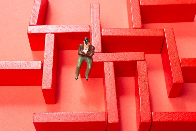 Photo man figurine and red wooden labyrinth maze elevated high angle view