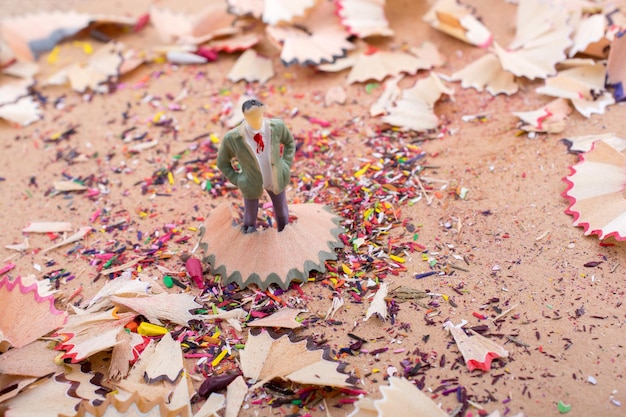 Man figurine standing amid pencil shavings