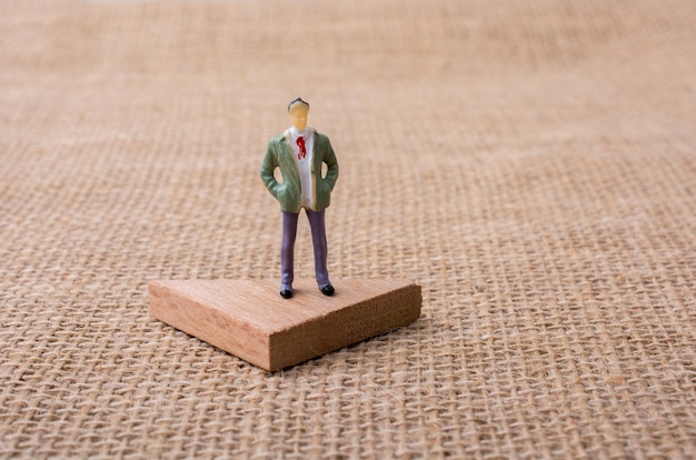 Man figurine standing on a triangle