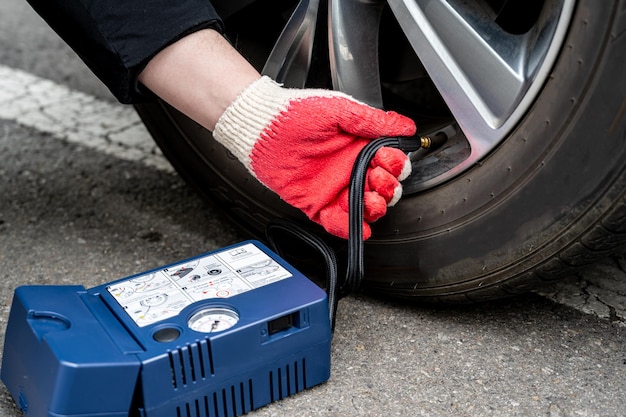 Photo man filling air into the tire. car driver checking air pressure.