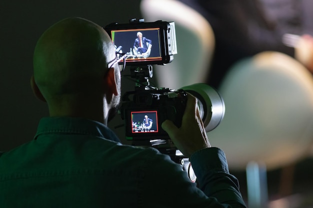 Man filming an old man on big camera