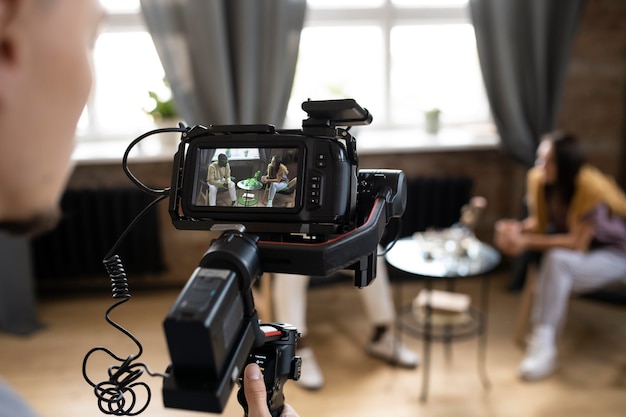 Foto uomo che filma con una telecamera professionale