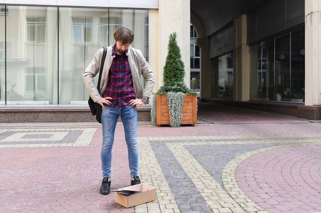 A man fired from his job because of the economic crisis against the backdrop of an office building