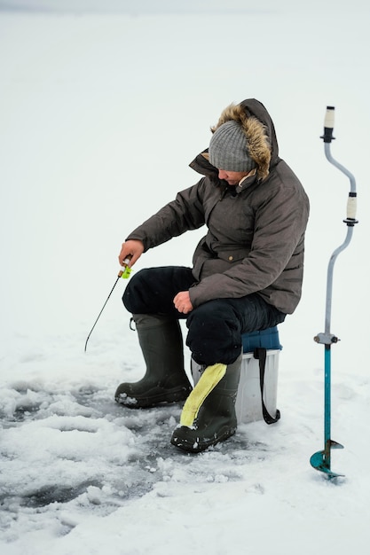 Photo man fishing alone outside in winter