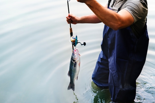 Foto uomo che pesca in riva al lago