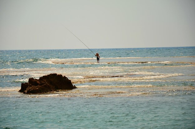 Фото Человек, ловящий рыбу в море на чистом небе.