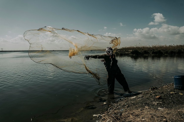 Photo man fishing in lake against sky