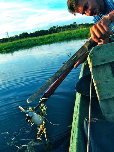 Foto uomo che pesca nel lago contro il cielo