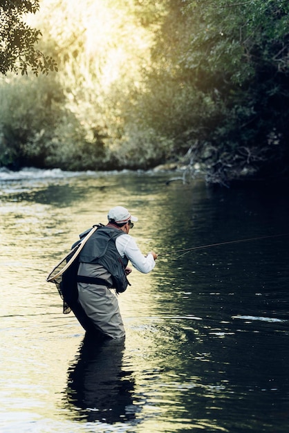 Photo man fishing in lake at forest